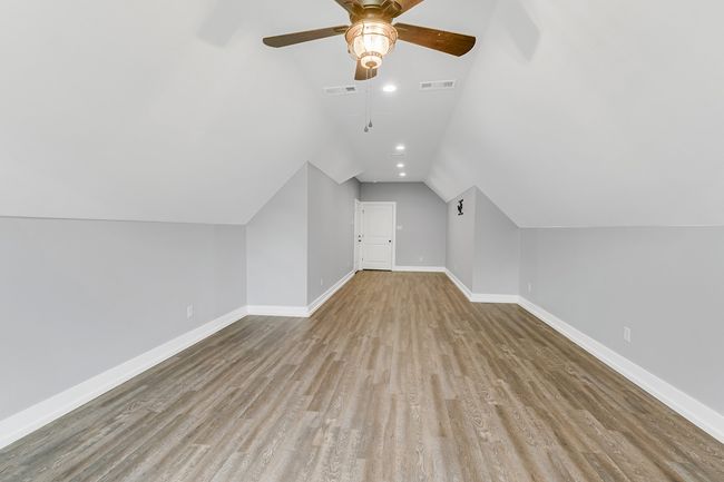 Bonus room featuring wood finished floors, ceiling fan, lofted ceiling, and baseboards | Image 30