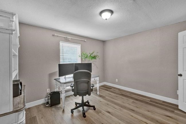 Home office featuring baseboards, wood finished floors, and a textured ceiling | Image 23
