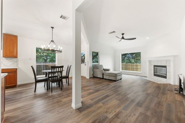 Dining area featuring a ceiling fan, healthy amount of natural light, dark wood-style flooring, and a chandelier | Image 16
