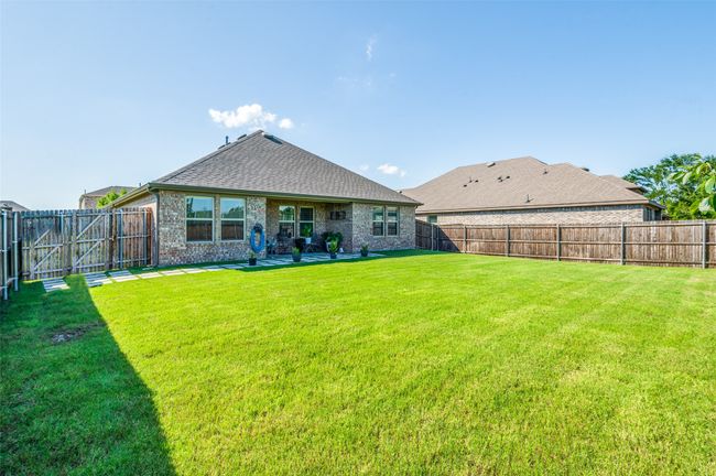 Rear view of property with a fenced backyard, a shingled roof, brick siding, and a gate | Image 25