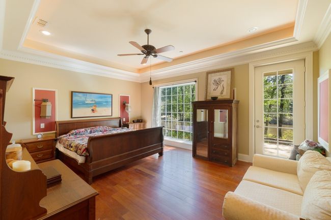 Bedroom with a tray ceiling, multiple windows, and access to outside | Image 16