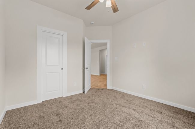 Unfurnished bedroom with carpet flooring, baseboards, and ceiling fan | Image 10