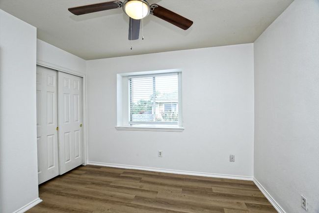 Unfurnished bedroom featuring wood finished floors, a closet, and a ceiling fan | Image 20