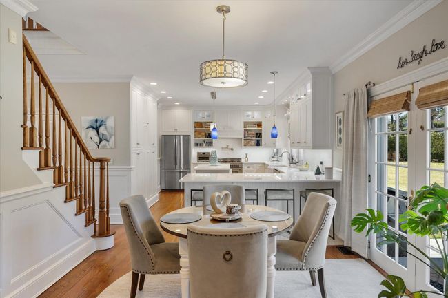 Dining room featuring crown molding, light wood-style floors, stairway, and wainscoting | Image 14
