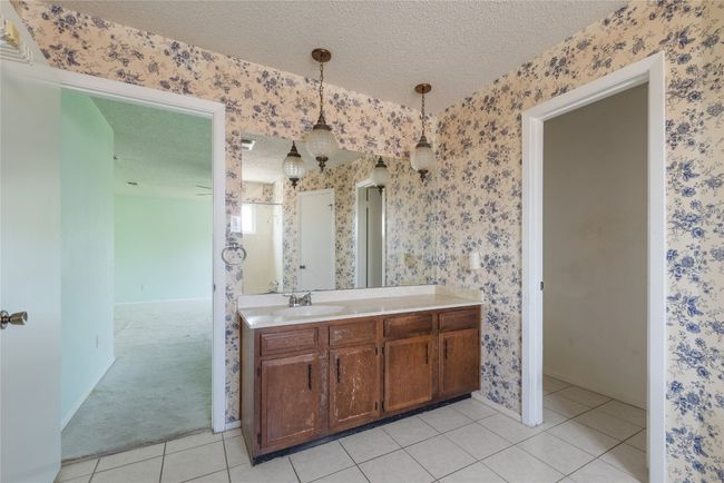 Bathroom featuring a textured ceiling, wallpapered walls, vanity, and tile patterned flooring | Image 15