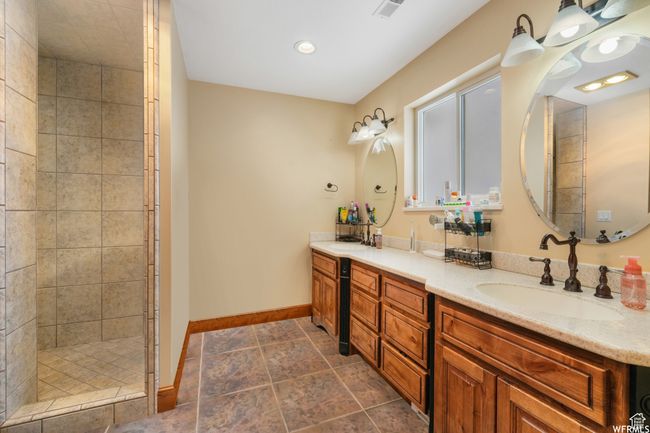 Bathroom with vanity, baseboards, tiled shower, and visible vents | Image 18