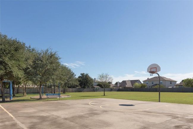 View of basketball court with community basketball court, fence, and a yard | Image 24