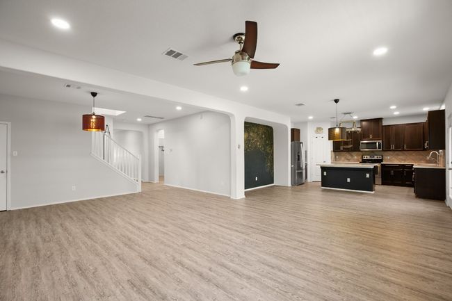 Unfurnished living room featuring visible vents, a ceiling fan, light wood finished floors, and recessed lighting | Image 18