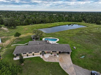 Drone view of home and pond | Image 1