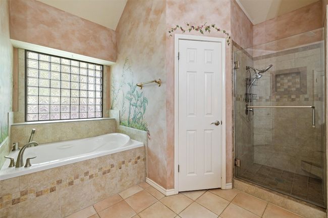 Full bathroom with a stall shower, a bath, tile patterned floors, and vaulted ceiling | Image 26