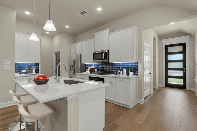 Kitchen featuring light wood-type flooring, tasteful backsplash, light countertops, recessed lighting, and vaulted ceiling | Image 7