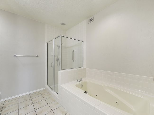 Bathroom featuring tile patterned floors, visible vents, a shower stall, and a jetted tub | Image 17