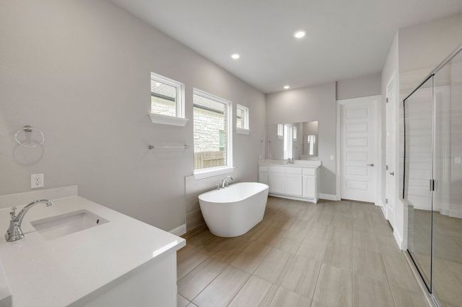 Full bathroom with two vanities, a stall shower, a soaking tub, and recessed lighting | Image 12
