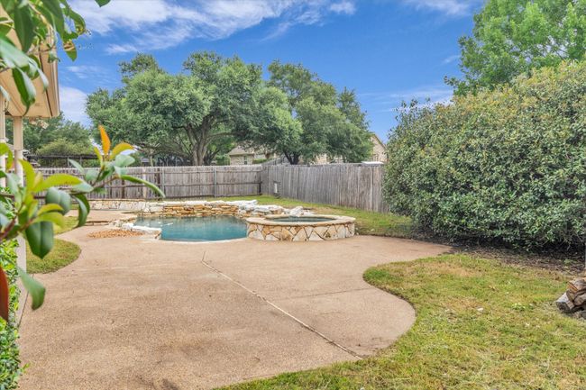 View of swimming pool with a patio, a fenced backyard, and a pool with connected hot tub | Image 33