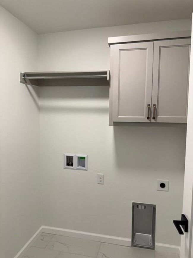 Laundry room with hookup for a washing machine, electric dryer hookup, cabinet space, marble finish floor, and baseboards | Image 37