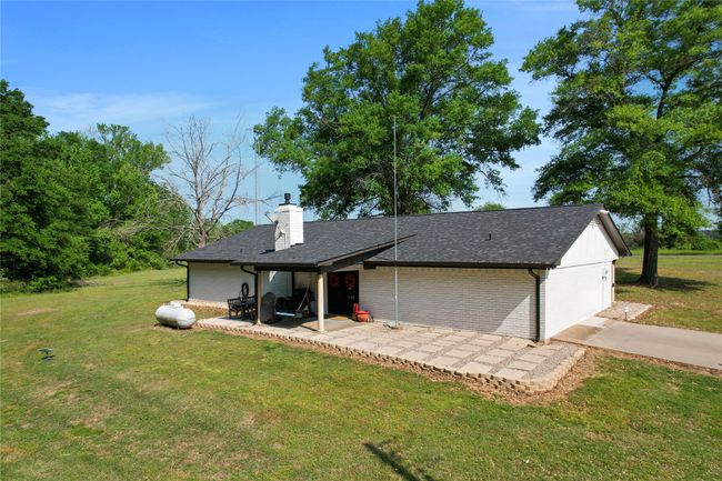 Back of house with a patio, a lawn, a chimney, and brick siding | Image 27