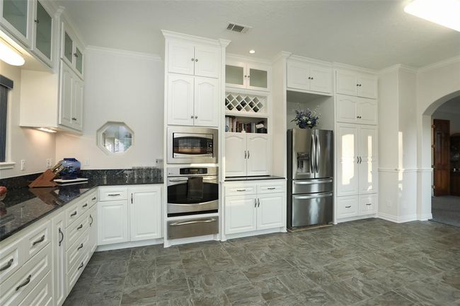 Another view of this magnificent kitchen. Kitchen has a wine rack for your wine bottle storage, shelf for your cookbooks and the hidden appliance garage. | Image 21