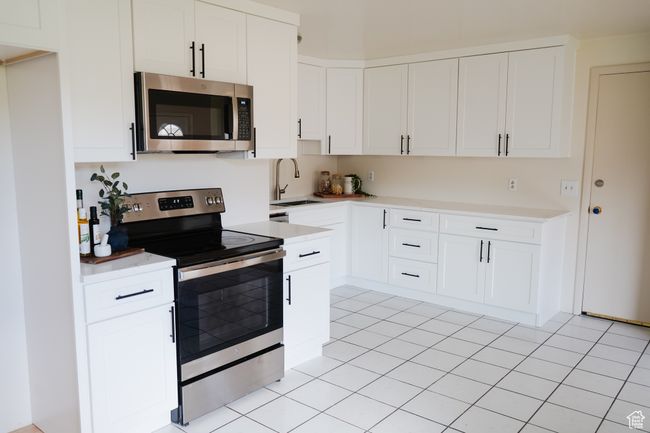 Kitchen with appliances with stainless steel finishes, light countertops, and light tile patterned flooring | Image 7