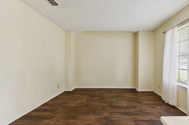 Empty room featuring a textured ceiling and dark wood-style floors | Image 5