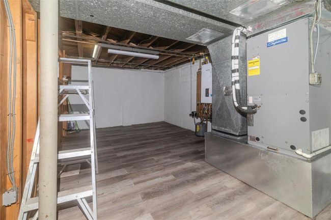 Finished basement with tankless water heater, heating unit, and wood finished floors | Image 27