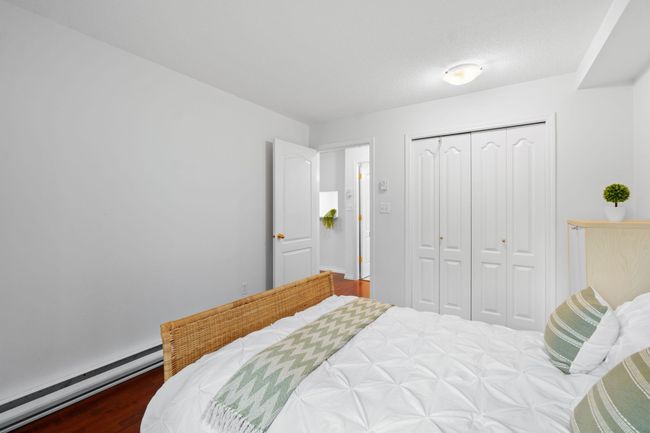 Bedroom featuring baseboard heating, a closet, and wood finished floors | Image 11