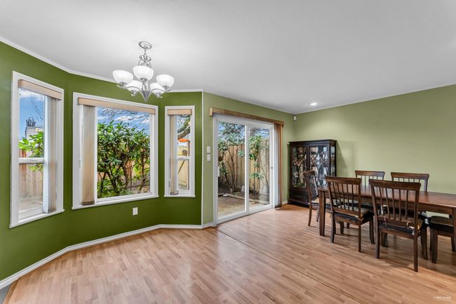 Dining space featuring baseboards, a chandelier, crown molding, recessed lighting, and wood finished floors | Image 10