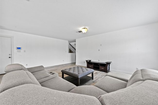 Living room with wood finished floors, stairs, and baseboards | Image 4
