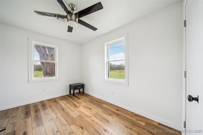 Spare room featuring hardwood / wood-style flooring, baseboards, and ceiling fan | Image 24