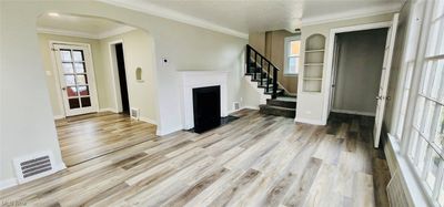 Unfurnished living room featuring a wealth of natural light, ornamental molding, and light hardwood / wood-style floors | Image 3