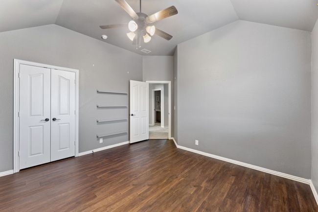 Bedroom featuring lofted ceiling, baseboards, light colored carpet, visible vents, and ceiling fan | Image 22