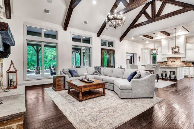 Living room with a chandelier, visible vents, high vaulted ceiling, and beam ceiling | Image 8