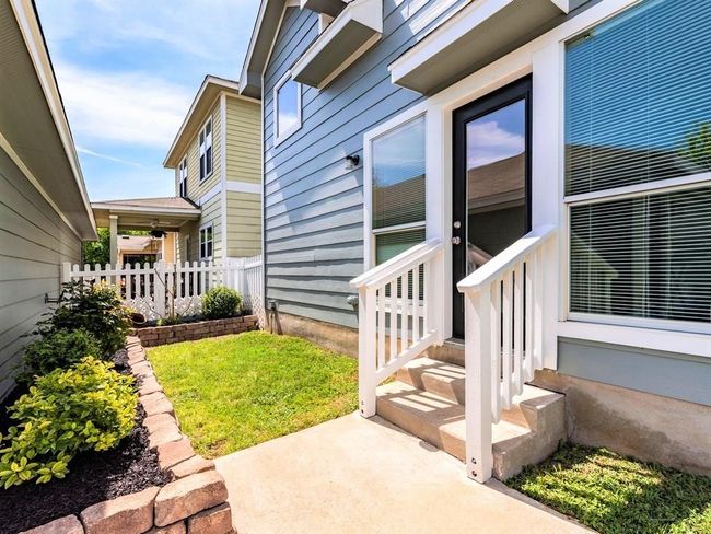 A darling fenced-in yard stretches off the back of the home with beautiful landscaping and two lawn areas. | Image 25