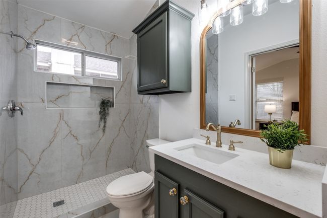 Bathroom with a marble finish shower, toilet, and vanity | Image 20