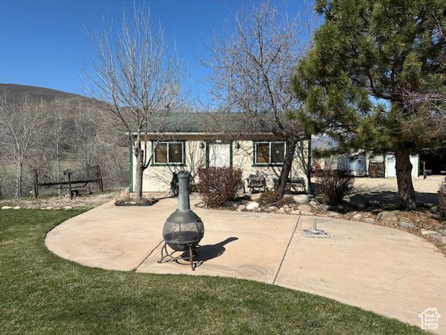 Rear view of property with an outdoor fire pit, a patio area, and a lawn | Image 6