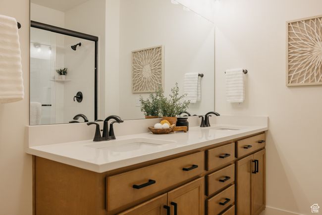 Bathroom featuring a tile shower, double vanity, and a sink | Image 17