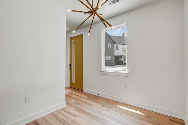 Empty room with a chandelier, light wood finished floors, and baseboards | Image 12