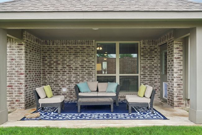 View of covered patio with an outdoor living space. Original exterior door in in the garage if doggy door needed to be replaced. | Image 35