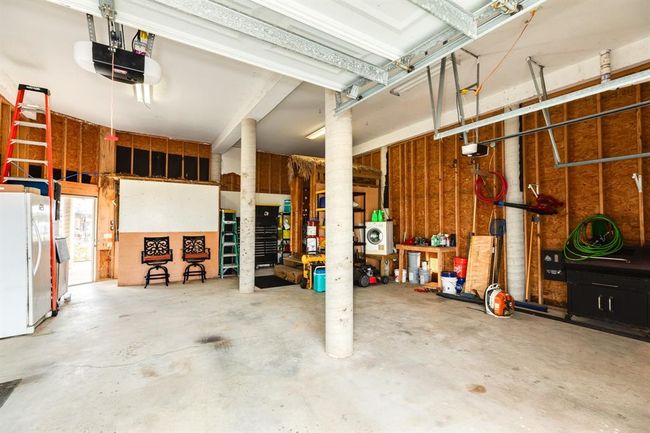 2 car garage features ample storage, and workspace. It includes a utility area with a washer/dryer, and various tools, making it ideal for projects and organization. | Image 47