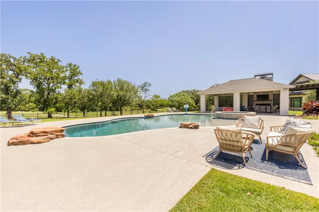 View of pool featuring a patio area, a pool with connected hot tub, and outdoor lounge area | Image 18