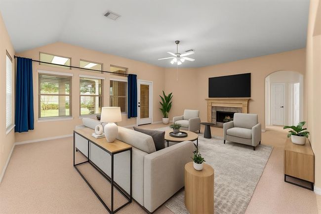 The spacious family room is filled with natural light from a wall of windows and showcases a cozy gas fireplace and high vaulted ceilings. Open to the kitchen and breakfast area, this inviting space is ideal for everyday living and effortless entertaining. Virtually staged | Image 15