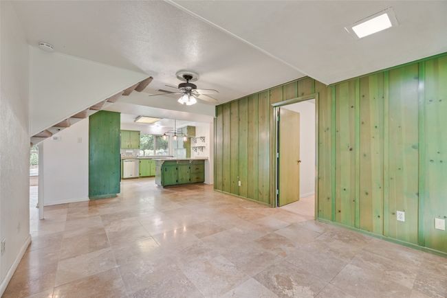 Empty room featuring a ceiling fan, baseboards, wooden walls, and a smoke detector | Image 11