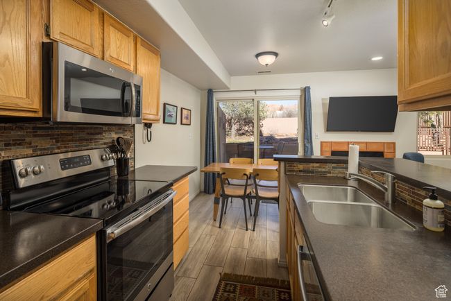 Kitchen with appliances with stainless steel finishes, backsplash, track lighting, and sink | Image 17