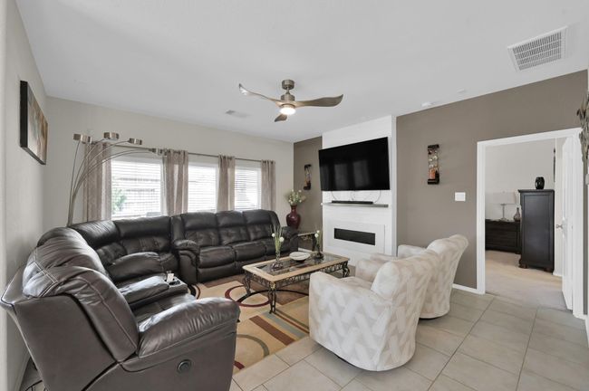 The welcoming living room is centered around a sleek electric fireplace. | Image 12