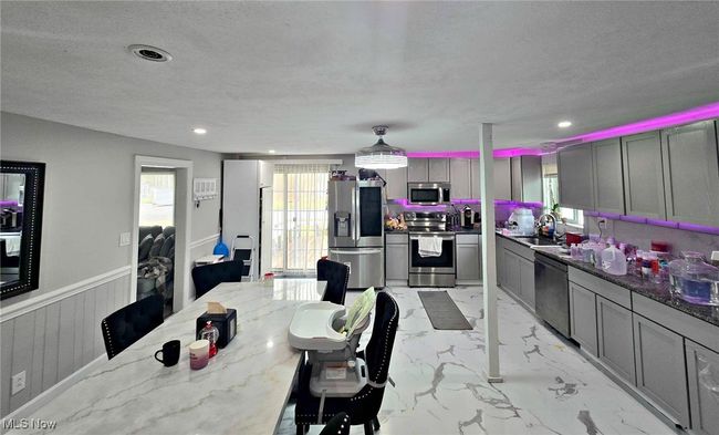 Dining space featuring recessed lighting, a wainscoted wall, marble finish floor, and a textured ceiling | Image 20