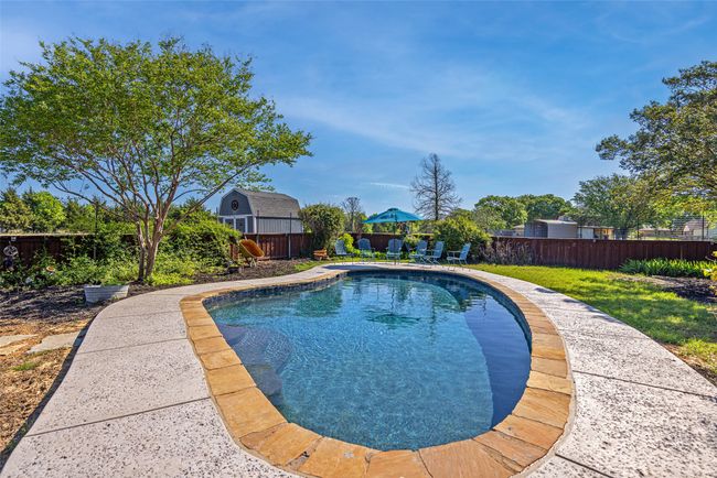 View of swimming pool with a fenced backyard | Image 26