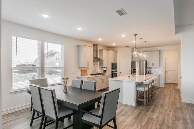 Dining space with a healthy amount of sunlight, wood-type flooring, and sink | Image 13