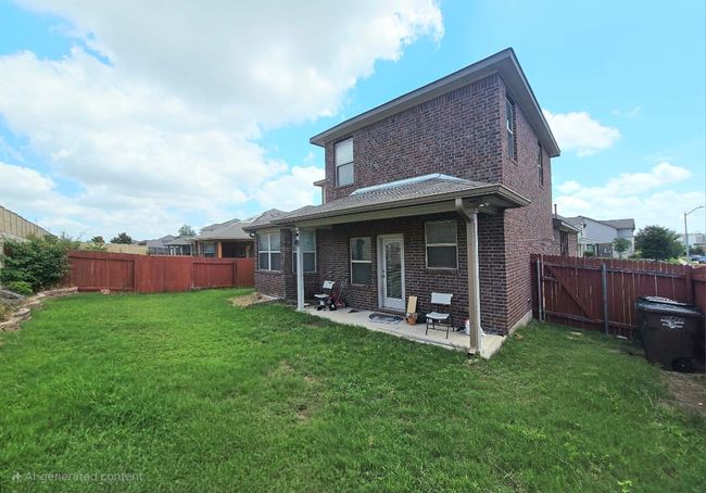 Back of property with brick siding, a patio area, and a fenced backyard | Image 26