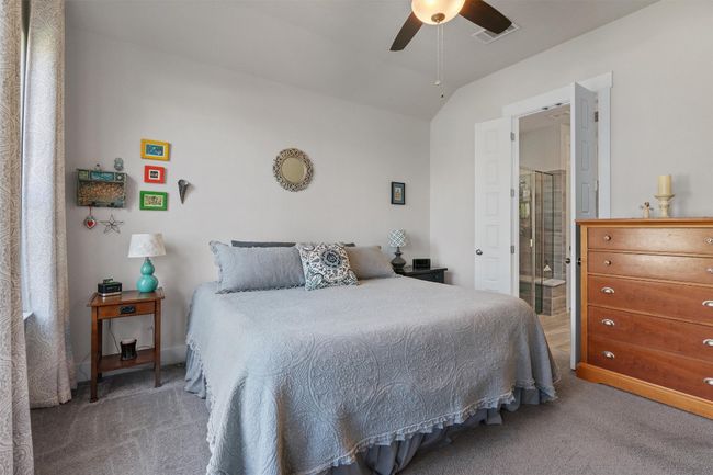Carpeted bedroom, a ceiling fan, ensuite bathroom. | Image 15