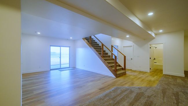 Unfurnished living room featuring stairs, wood finished floors, and recessed lighting | Image 38