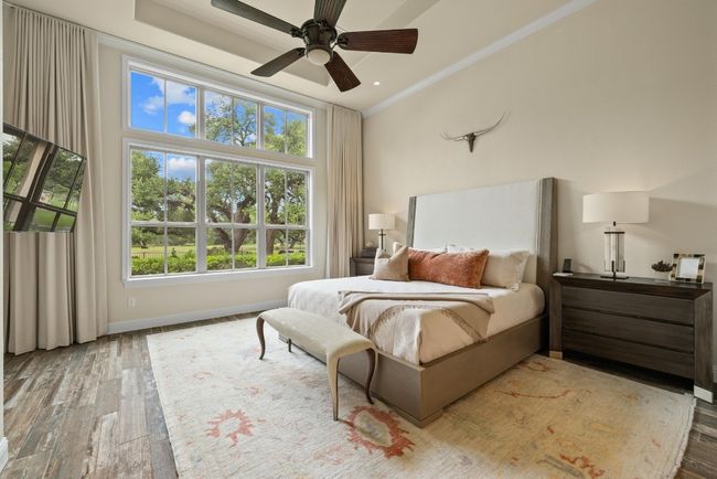 Bedroom with multiple windows, wood finished floors, baseboards, and ornamental molding | Image 17